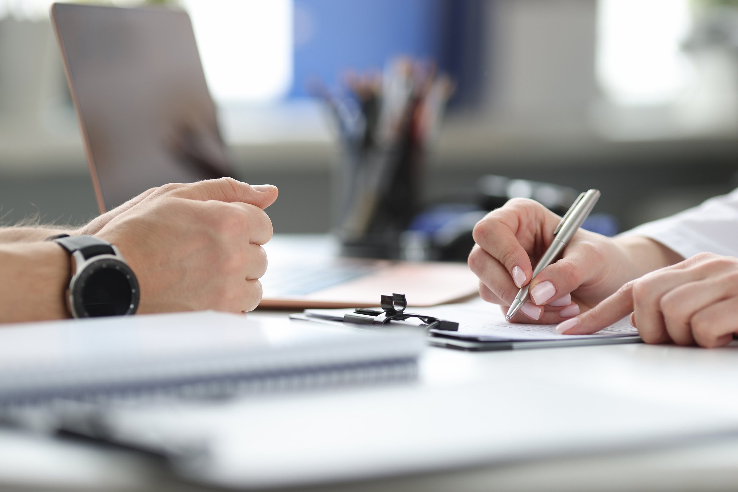 Doctor Filling Out Medical Documentation at Patient Appointment