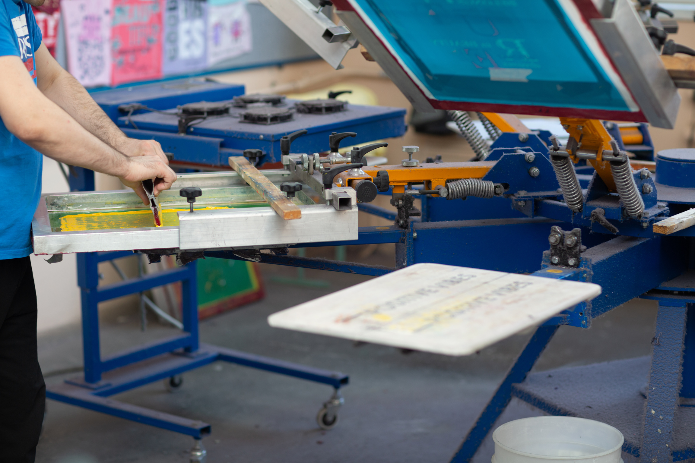 Serigraphy Silk Screen Print Process at Clothes Factory. Frame, Squeegee and Plastisol Color Paints